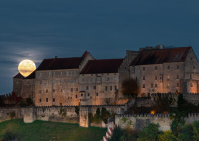 Vollmond hinter einer Burg am Abend.